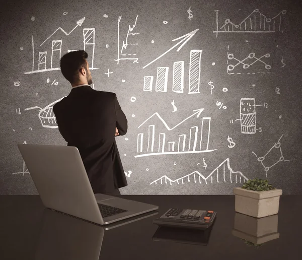 Businessman drawing sales charts on wall — Stock Photo, Image