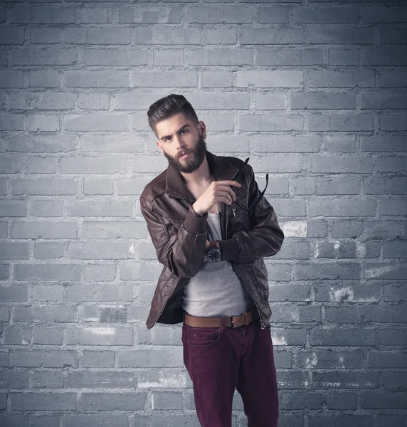 Fashion model in front of brick urban wall