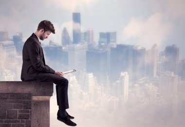 Yüksek bir binanın tepesinde oturan satıcı.