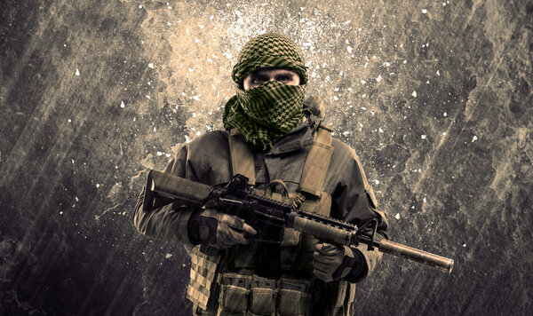 Опасный человек в маске и вооруженный, с террористической надписью на груди
