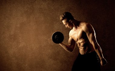 Kas formundaki vücut geliştirici sporcu ağırlık kaldırıyor 