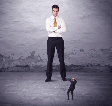 Kızgın büyük müdür küçük iş adamına bakıyor.