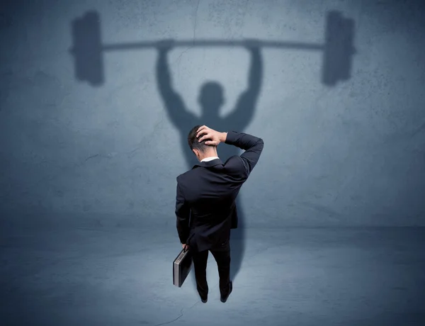 Businessman with weight lifting shadow — Stock Photo, Image