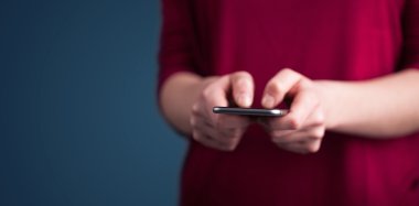 Akıllı telefonu elinde tutan genç bir kadın. 