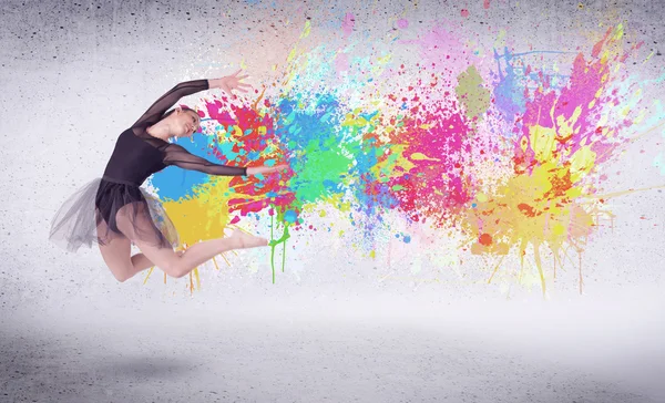 Bailarina callejera moderna saltando con salpicaduras de pintura de colores — Foto de Stock