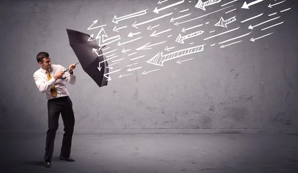 Business man standing with umbrella and drawn arrows hitting him — Stock Photo, Image