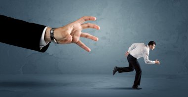 İş adamı büyük bir el kavramından kaçıyor.
