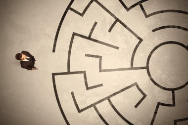 Lost business man looking for a way in circular labyrinth clipart
