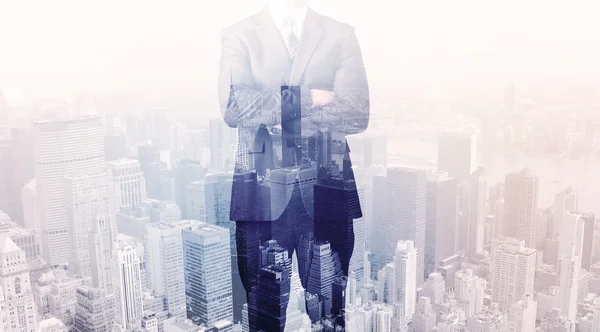 İş adamı çatıda duruyor ve arka planda şehir var.