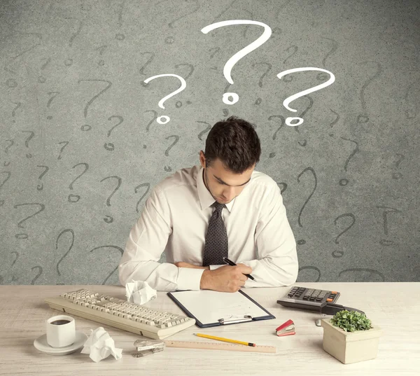 İş adamı soru işaretiyle masada.