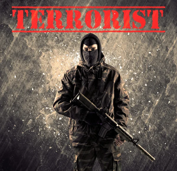 Peligroso hombre enmascarado y armado con signo terrorista en Grungy Bac — Foto de Stock