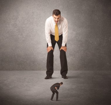 Büyük iş adamı küçük işçilere bakıyor.