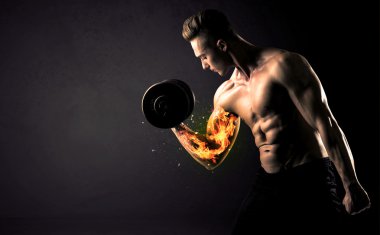 Vücut geliştirme sporcusu ateşli kol konseptiyle ağırlık kaldırıyor