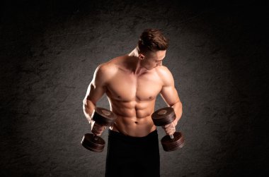 Seksi halterci adam kaslarını gösteriyor.