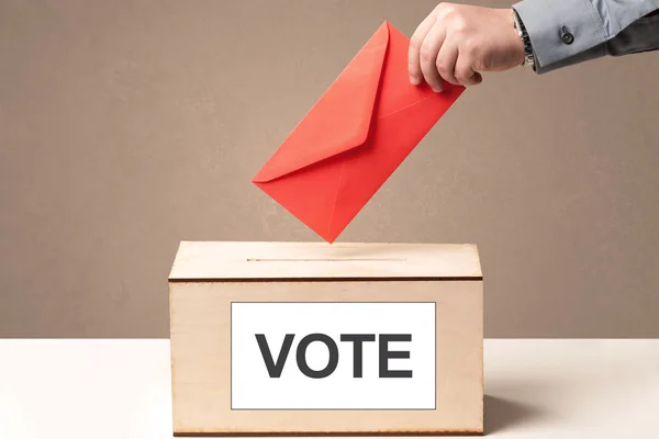 Primo piano della mano maschile che mette il voto nelle urne — Foto Stock