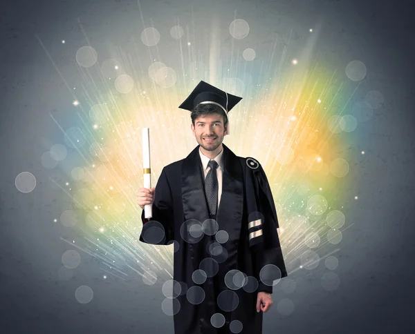 Feliz graduado con luces bokeg de colores en el fondo — Foto de Stock