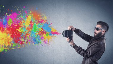 Kamera ve boya sıçratan hippi adam.