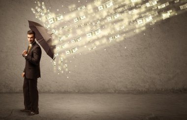 İş adamı dolar yağmuruna karşı şemsiye tutuyor