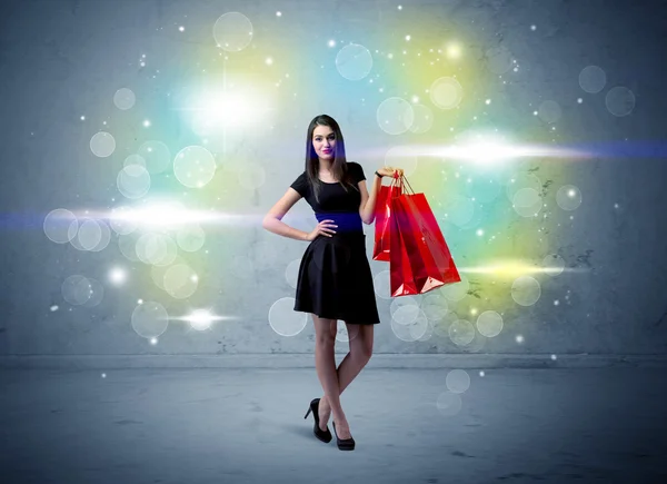 Winkeldame met boodschappentassen en glitterlicht — Stockfoto