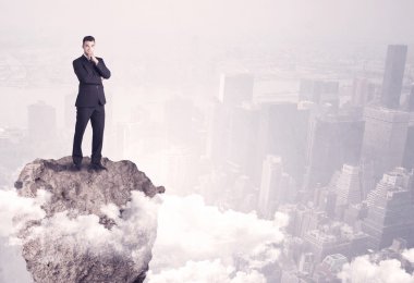 Kayanın üzerinde duran kazanan iş kişi