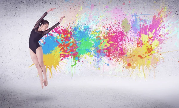 Moderne street danser springen met kleurrijke verf spatten — Stockfoto