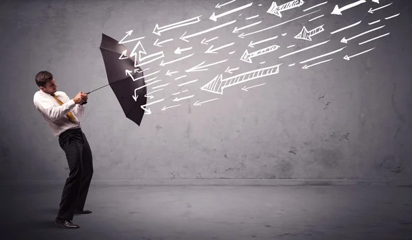 Business man standing with umbrella and drawn arrows hitting him — Stock Photo, Image