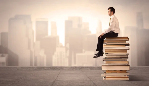 Mann sitzt auf Büchern in der Stadt — Stockfoto