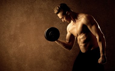 Kas formundaki vücut geliştirici sporcu ağırlık kaldırıyor 