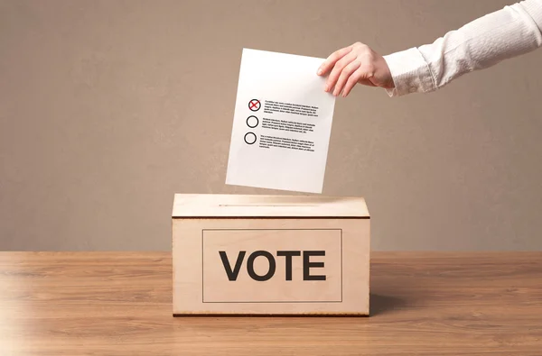 A férfi keze szavazás üzembe a szavazólapon doboz közelről — Stock Fotó