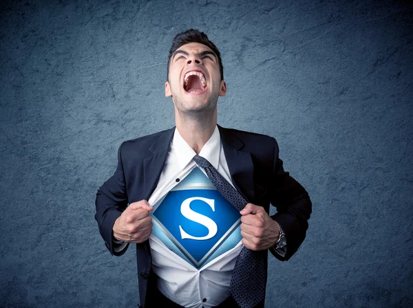 Businessman ripping off his shirt with superhero sign — Stock Photo, Image