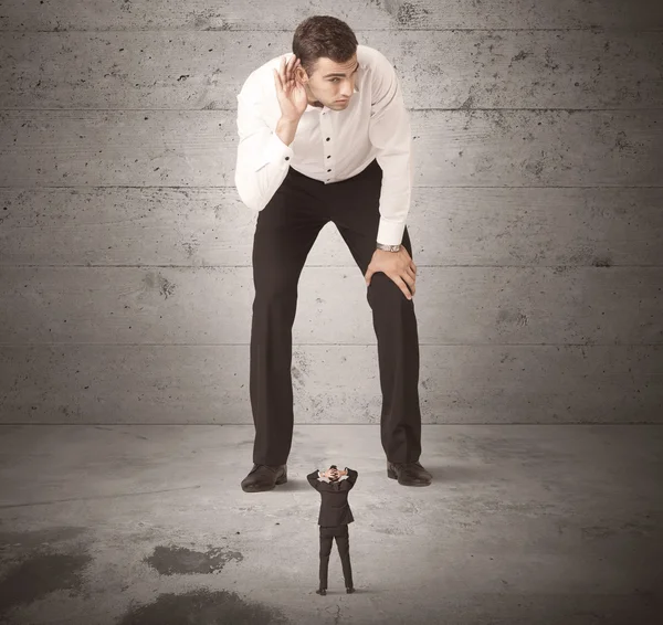 Büyük bir iş adamı küçük bir iş arkadaşına bakıyor.