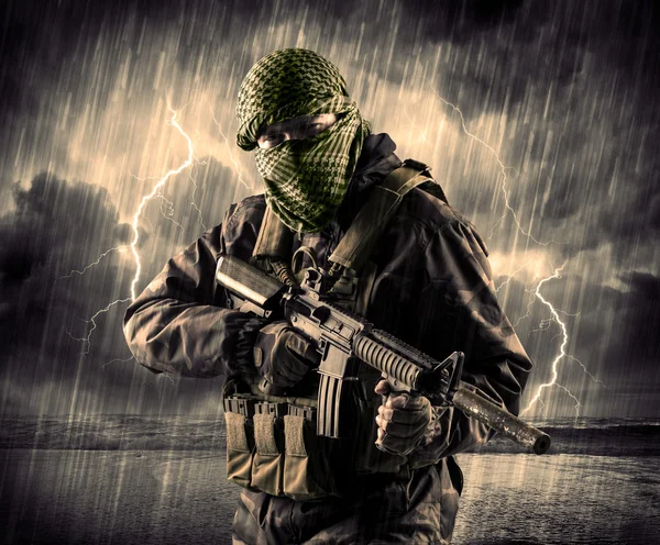 Gevaarlijke gewapende terrorist met masker en pistool in een onweersbui wi — Stockfoto
