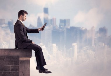 Yüksek bir binanın tepesinde oturan satıcı.