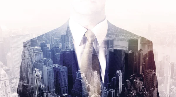 Business man standing on roof with city in the background — Stock Photo, Image