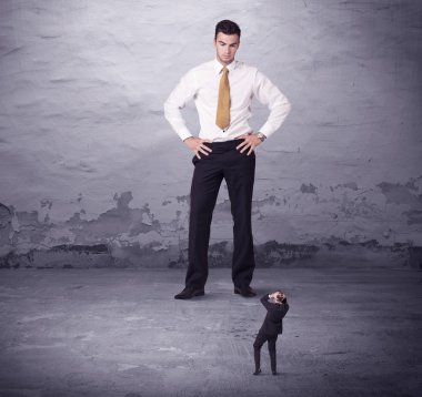 Kızgın büyük müdür küçük iş adamına bakıyor.