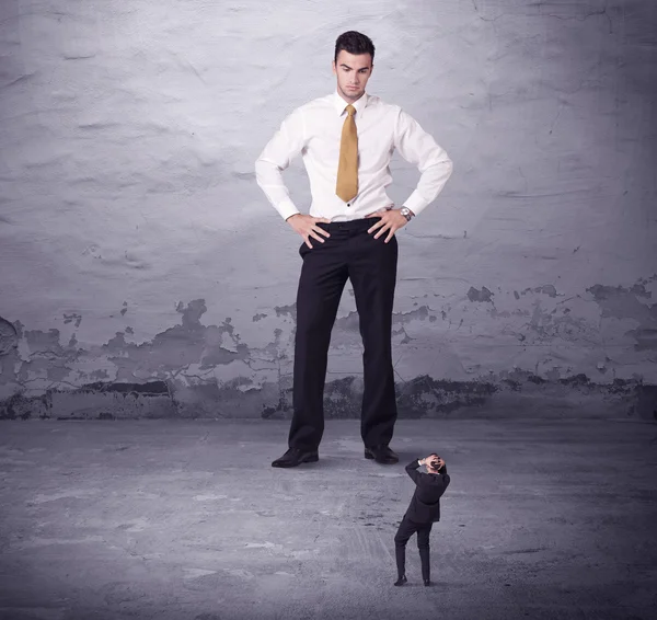 Kızgın büyük müdür küçük iş adamına bakıyor.