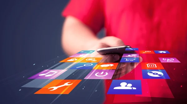 Hombre sosteniendo el teléfono inteligente con iconos de aplicación de colores —  Fotos de Stock