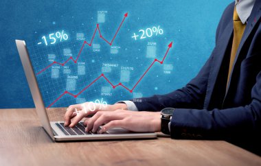 Satıcı dizüstü bilgisayarla grafikle çalışıyor.