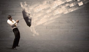 İş adamı ile şemsiye kağıtları rüzgara karşı koruma