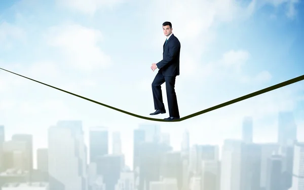 Salesman walking on rope above the city — Stock Photo, Image