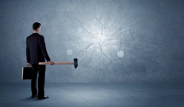 Homme d'affaires frappant mur avec un marteau — Photo