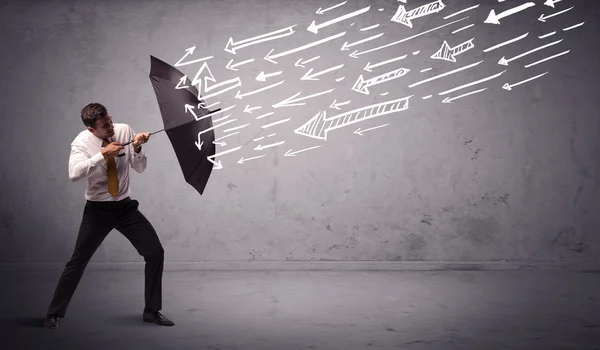 Business man standing with umbrella and drawn arrows hitting him — Stock Photo, Image