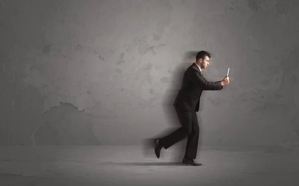 Running businessman with device in hand — Stock Photo, Image