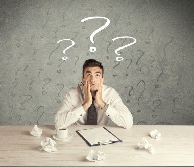 İş adamı soru işaretiyle masada.