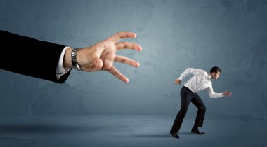 İş adamı büyük bir el kavramından kaçıyor.