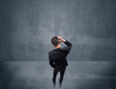 Şehir duvarının önünde duran iş adamı