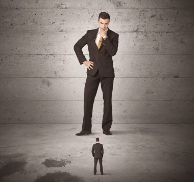 Büyük bir iş adamı küçük bir iş arkadaşına bakıyor.