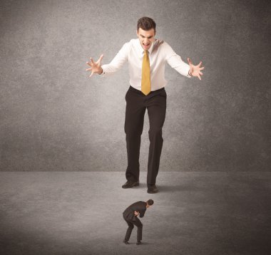 Büyük iş adamı küçük işçilere bakıyor.