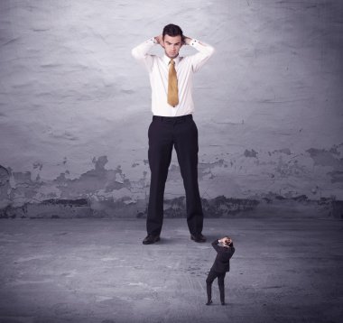 Kızgın büyük müdür küçük iş adamına bakıyor.