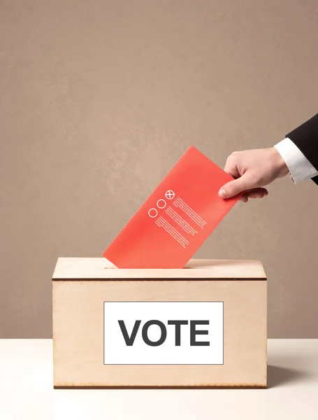 Close up of male hand putting vote into a ballot box — Stock Photo, Image